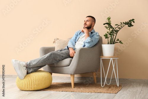 Young man sitting in armcha...