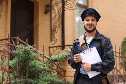 Handsome postman with clipb...