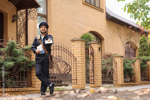 Handsome postman with lette...