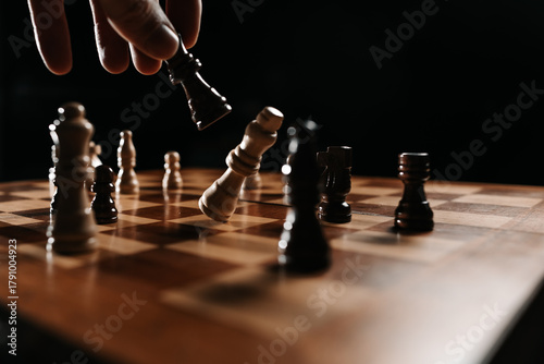 Fotografie Close view of a black piece striking the white king, capturing a dramatic finishing move and the concept of victory over an opponent