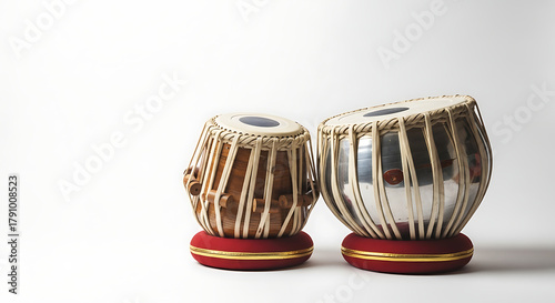 Close up view of two tabla drums sitting on red cushions against a plain white background studio shot ai generated