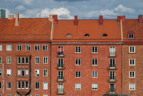 Facade of red brick residential building with windows.