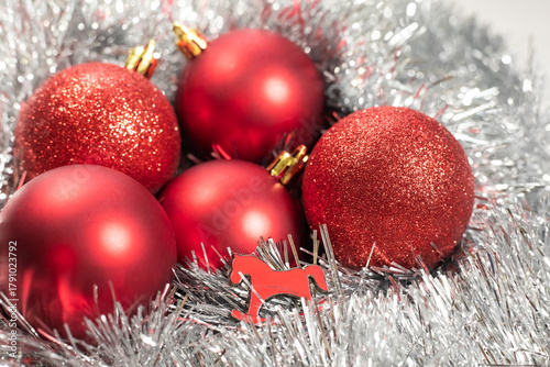Red Christmas balls and a red horse icon are a symbol of the New Year, 2026, in silver tinsel.