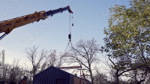A modular house is lifted by a truck crane.