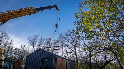 The boom of a truck crane lifting a house.