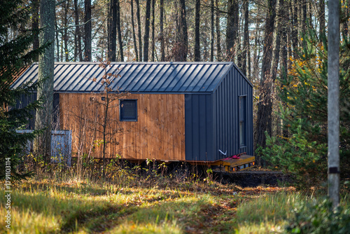 The modular house is transported through a forested area.