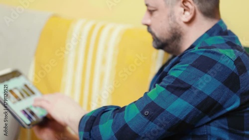 Man chooses film or Tv show to watch on an online steaming service app at home.