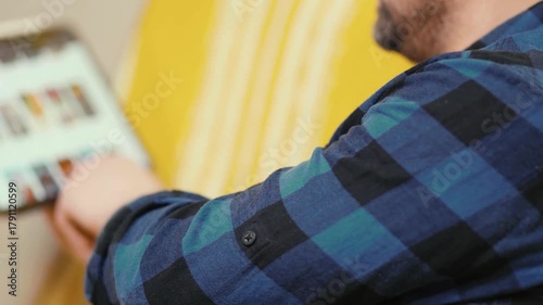 Man chooses film or Tv show to watch on an online steaming service app at home.