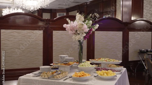 A beautifully arranged catering buffet with fresh fruit, salads, and wraps. Elegant and luxurious setting for a wedding or corporate event. Ideal for hospitality and celebration concepts.