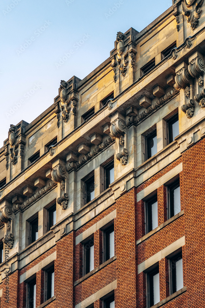 Obraz premium Detailed view of historic architecture with ornate stonework and red brick facade in downtown Montreal, Quebec