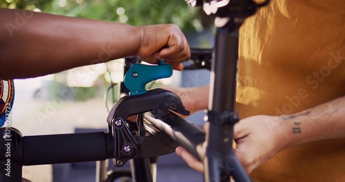 Tableau sur toile Close-up shot of caucasian man carrying bike and african american woman clamping the frame to repair-stand for maintenance