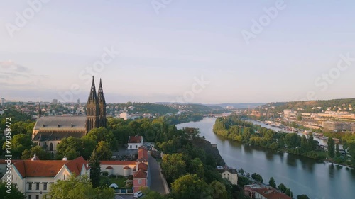 Experience the breathtaking sunrise over Vysehrad Basilica of St. Peter and St. Paul. This stunning aerial view captures the beauty of Prague's historic landmark and the serene Vltava River.