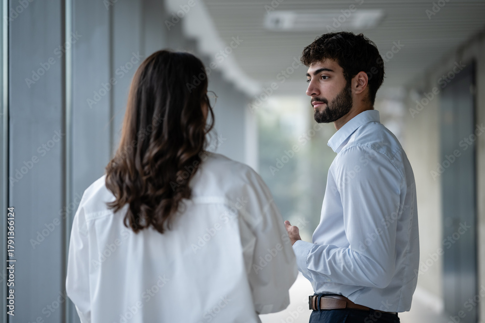Obraz premium Colleagues having a conversation in a modern office hallway