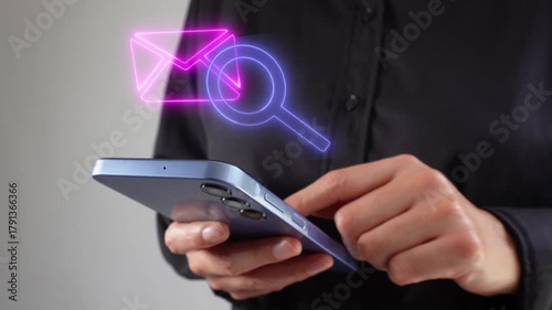 Analyzing messages in the inbox. Businesswoman with smartphone in hand, viewing a virtual icon of a mail envelope with a magnifying glass.