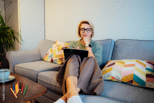 Middle aged woman planning goals for next new year while sitting on the sofa at home. Self-reflection, plans, action, checklist concept. Personal Year review. Coaching tools. Finding Balance in Life