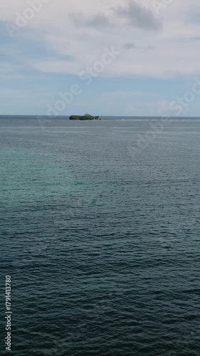 Calm tropical sea with coral formations showing beneath clear blue water. Siargao, Philippines.