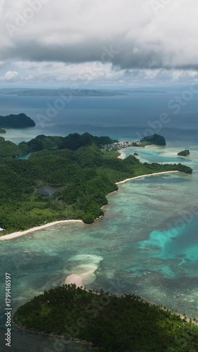Forested island coastline with white sandy beaches and turquoise shallow water. Sugba Blue Lagoon. Siargao, Philippines.
