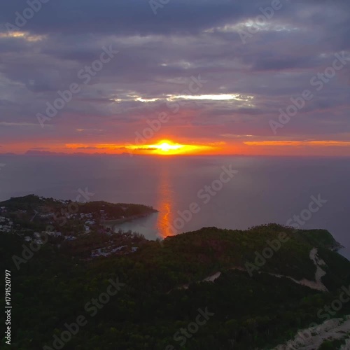 square Nature sea orange vivid sunset drone offers an aerial view of peaceful seaside surroundings.