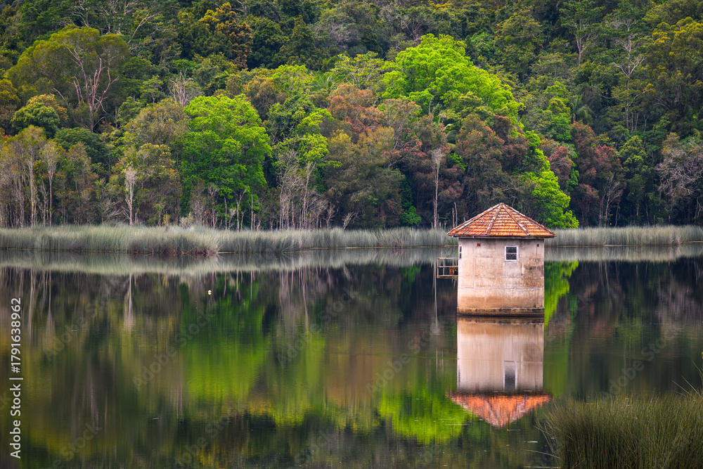 Obraz premium An old stone water tower in the middle of a dam - horizontal