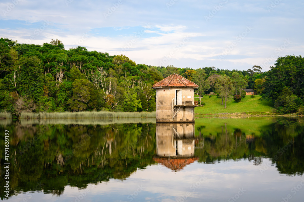 Obraz premium An old stone water tower in the middle of a dam - horizontal