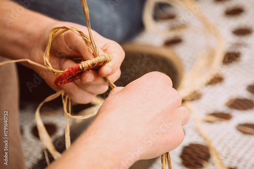 Indigenous craft - hands weaving with grass and fibre - horizontal