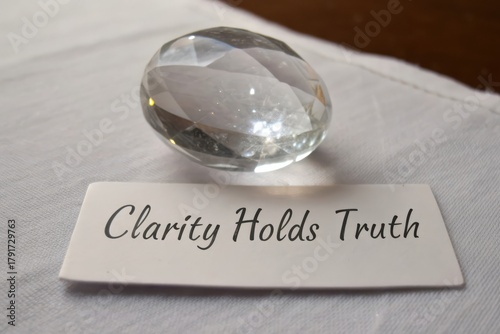 Polished crystal stone resting on a card with message clarity holds truth