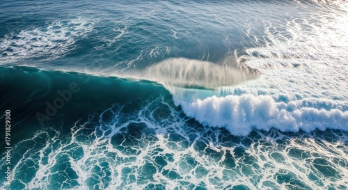 Fototapeta Naklejka Na Ścianę i Meble -  Aerial view of a large ocean wave cresting and breaking into white foam.