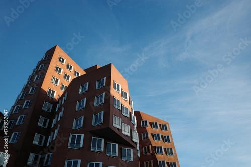 A dramatic, low-angle shot of the unique, modern architecture in Düsseldorf, Germany's Media Harbour (MedienHafen).