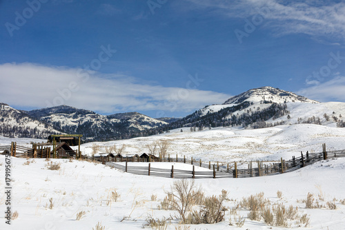 Quiet Winter Ranch Fence Beneath Snowy Mountain Peaks