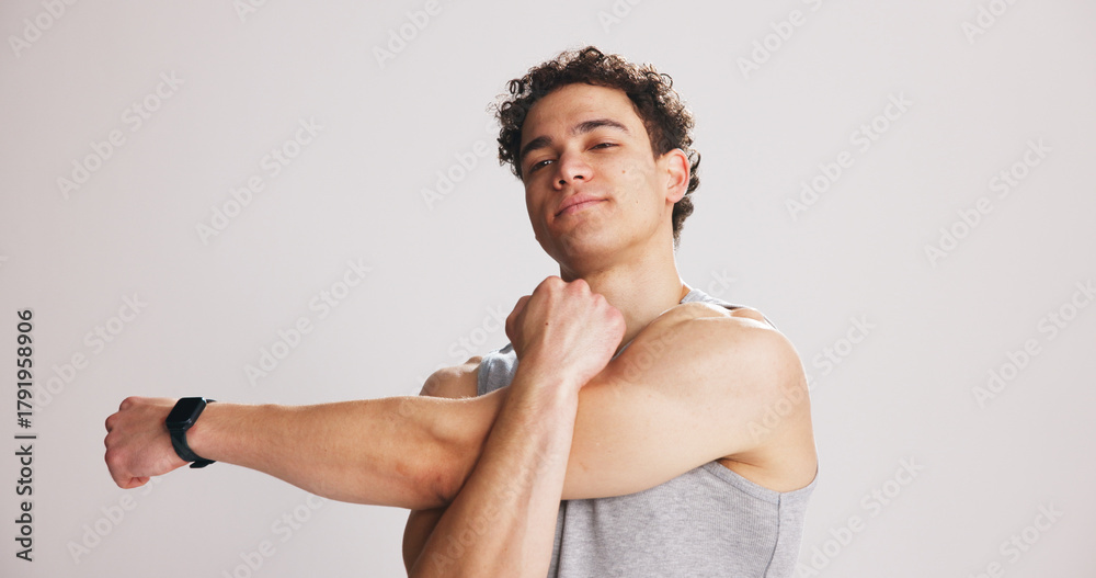 Fototapeta premium Arm, exercise and portrait of man stretching on studio space for start of training or workout routine. Fitness, shoulder and warm up with person on gray background mockup for challenge or performance