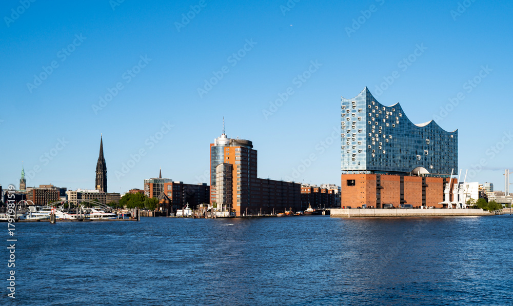 Naklejka premium Elbphilharmonie Hamburg reflects modern architecture. Elbphilharmonie attracts global visitors. Elbphilharmonie Hamburg stands above the Elbe River.