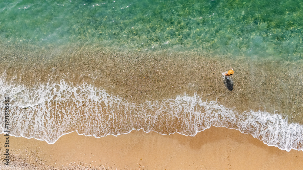 Naklejka premium Aerial drone view of sandy beach and turquoise sea waves with people sunbathing, swimming and relaxing, holiday vacation concept, Antalya Konyaalti beach, Turkey
