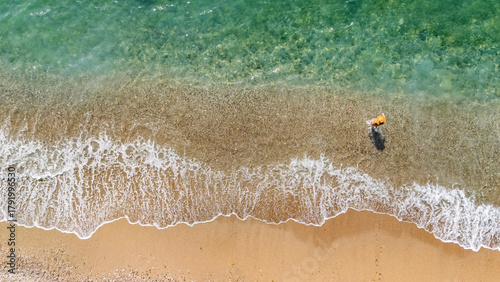 Fototapeta Naklejka Na Ścianę i Meble -  Aerial drone view of sandy beach and turquoise sea waves with people sunbathing, swimming and relaxing, holiday vacation concept, Antalya Konyaalti beach, Turkey