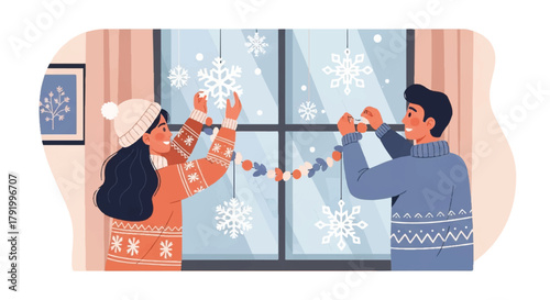 A young couple decorating a window with snowflake ornaments in a cozy room with warm lighting and winter clothing.