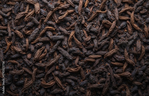 Dried black tea leaves form a rich dark texture. These aromatic long tea leaves are unfurled, ready for brewing a hot drink. Loose tea composition offers natural ingredients for herbal infusion.