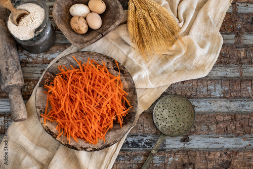 Different types of uncooked pasta on rustic wooden table, in the spoons, cutting board and bowls 