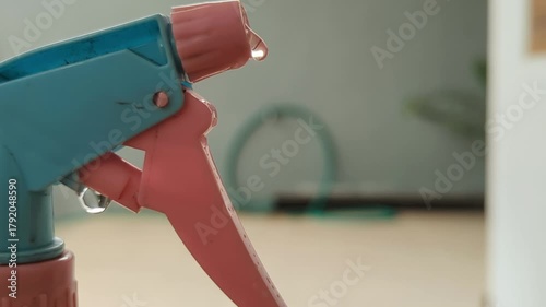 Spray bottle drips water onto a counter in a home kitchen, showing cleanliness and hygiene in a domestic setting.