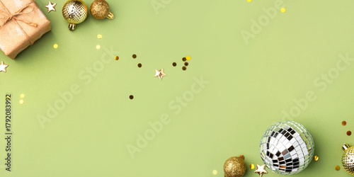 Christmas gift with gold ornaments on a green background.