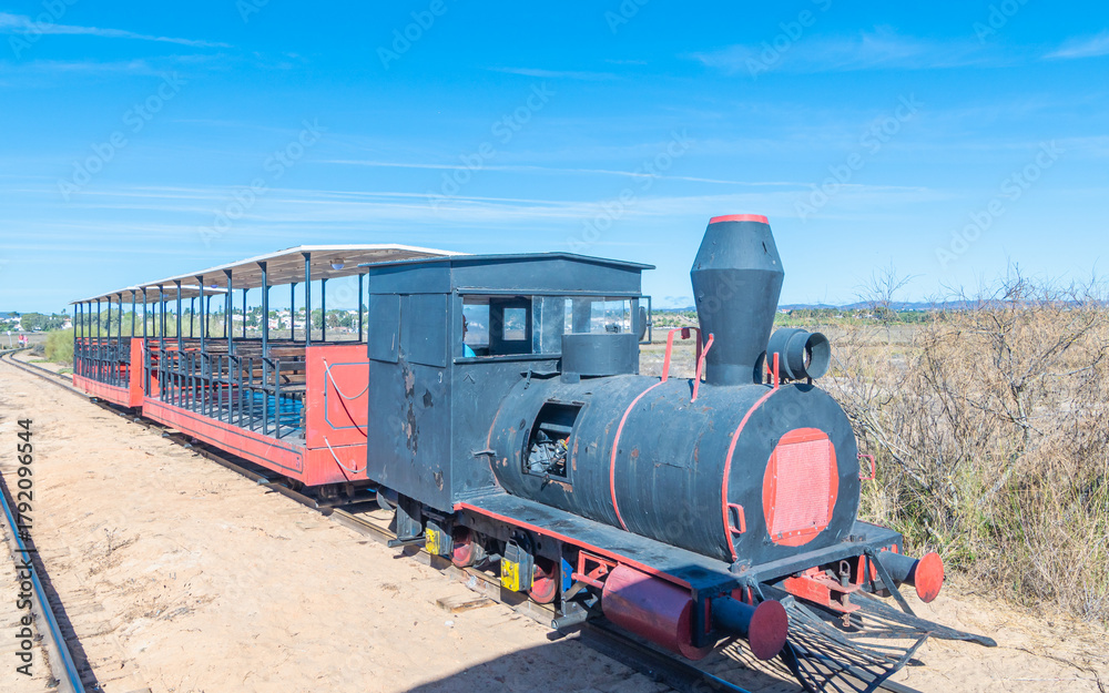 Naklejka premium Petit train touristique pour aller à la plage du cimetière des ancres, dans le sud du Portugal en Algarve.
