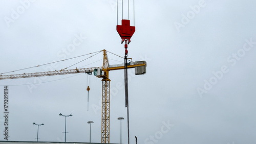 Tablou pe pânză Towering crane dances in muted skyline, orchestrating urban metamorphosis, echoi