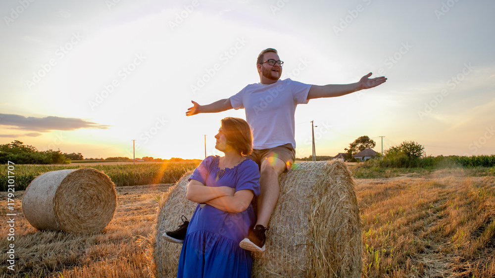 Αυτοκόλλητο Sunset-drenched fields cradle carefree laughter, with a Caucasian couple embodyi