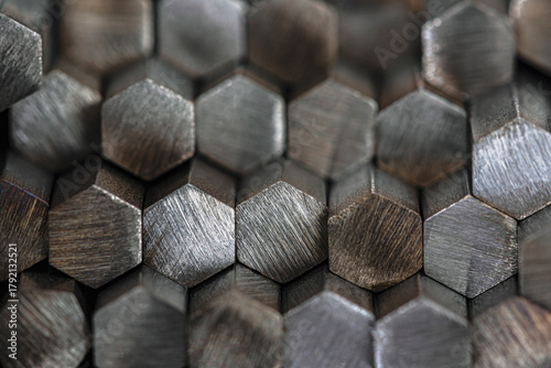 Stack of shiny nonferrous metal rods stored in industrial factory warehouse, close-up view