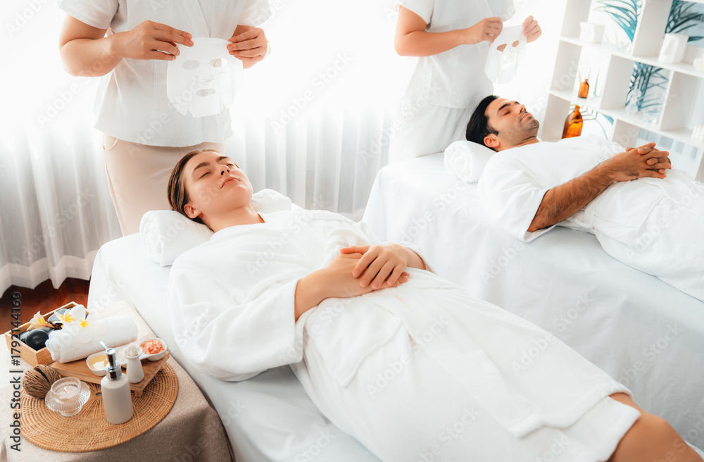 Obraz premium Serene modern daylight ambiance of spa salon, couple customer indulges in rejuvenating with facial skincare mask. Facial skin treatment and beauty cosmetology procedure for face. Quiescent