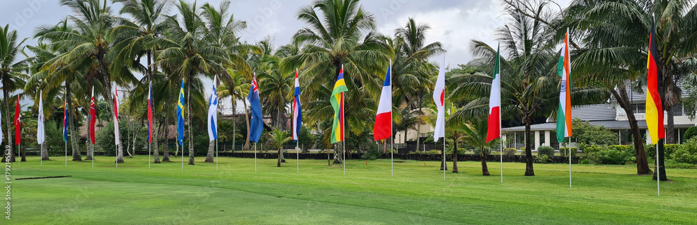Fototapeta premium International Flags Displayed on a Green Lawn in the Caribbean