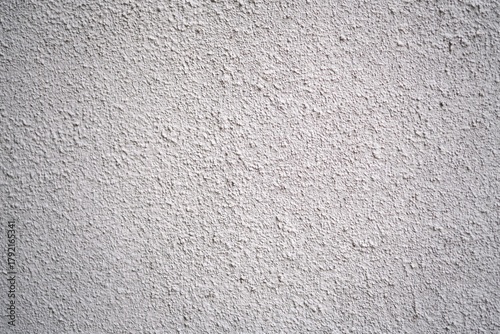 Close-up of a white plaster wall with a coarse, gritty texture, commonly used in exterior or interior architectural finishes.
