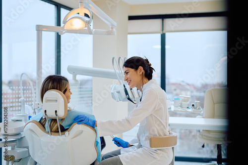 Dentist smiling and reassuring patient in a modern dental office, focusing on comfort and oral care experience