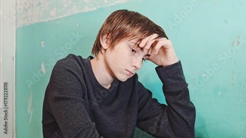 Alone, depression and regret with young man in home with memories or nostalgia. Relax, sad and thinking with unhappy guy. sad guy in an apartment with an old, unkempt interior. concept of poverty 