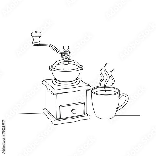 Vintage manual coffee grinder next to a steaming cup of coffee