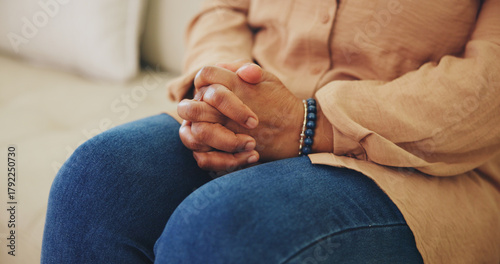 Photos Hands, nervous and thinking with person on sofa in living room of home for anxiety or tension