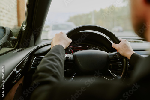 Bilde på lerret Caucasian young adult man driving car, gripping steering wheel with both hands,